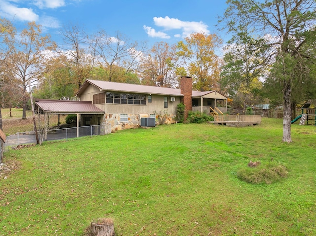 back of house featuring a playground, central air condition unit, and a yard