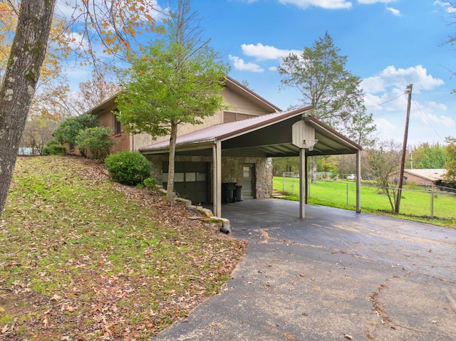 view of parking / parking lot featuring a lawn and a carport