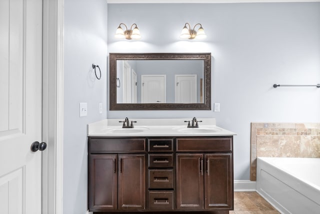 bathroom with tile patterned flooring, a bath, and vanity