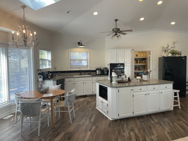 kitchen with white cabinets, a center island, lofted ceiling with skylight, and black appliances