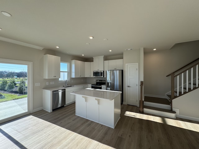 kitchen featuring white cabinetry, plenty of natural light, a kitchen island, and appliances with stainless steel finishes