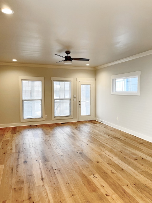 spare room featuring ceiling fan, light wood-type flooring, and crown molding