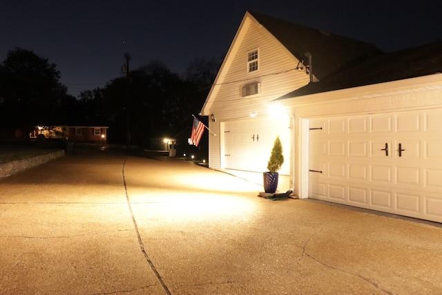 view of garage at twilight