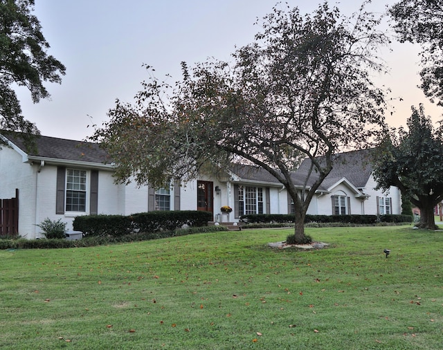 ranch-style home with a yard