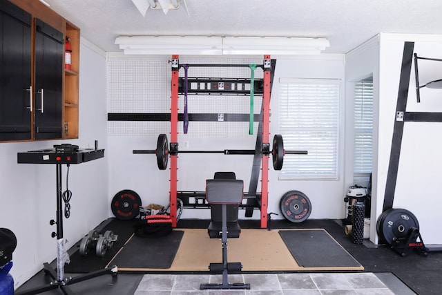 exercise area featuring ornamental molding and a textured ceiling