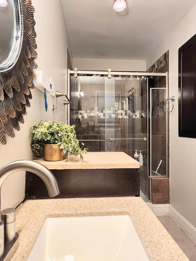 bathroom featuring vanity and a shower with door