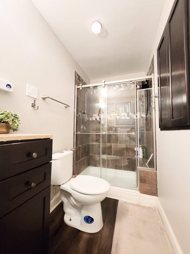 bathroom featuring vanity, toilet, and a shower with door