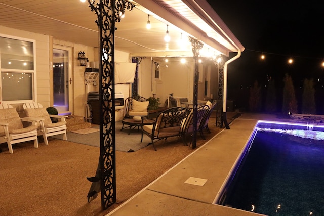 pool at twilight with a patio area