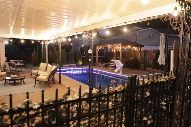 view of swimming pool featuring a gazebo, a patio, and a water slide