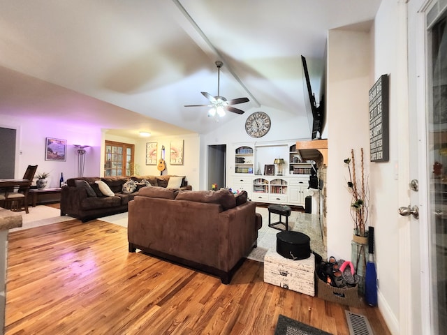 living room featuring hardwood / wood-style flooring, vaulted ceiling with beams, and ceiling fan