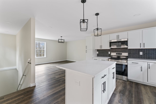 kitchen featuring dark hardwood / wood-style flooring, stainless steel appliances, decorative light fixtures, white cabinets, and a center island