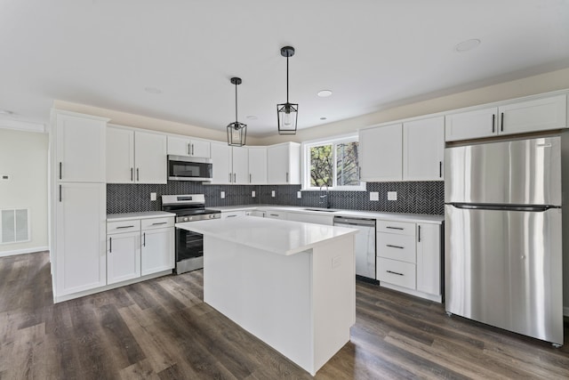 kitchen with dark hardwood / wood-style flooring, a center island, white cabinets, and appliances with stainless steel finishes