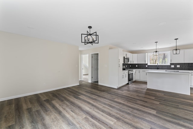 kitchen featuring pendant lighting, stainless steel appliances, a kitchen island, and dark hardwood / wood-style floors