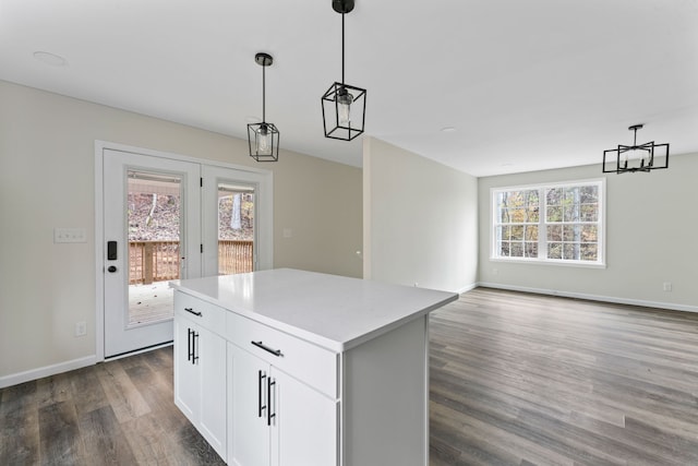 kitchen with white cabinets, plenty of natural light, dark wood-type flooring, and decorative light fixtures