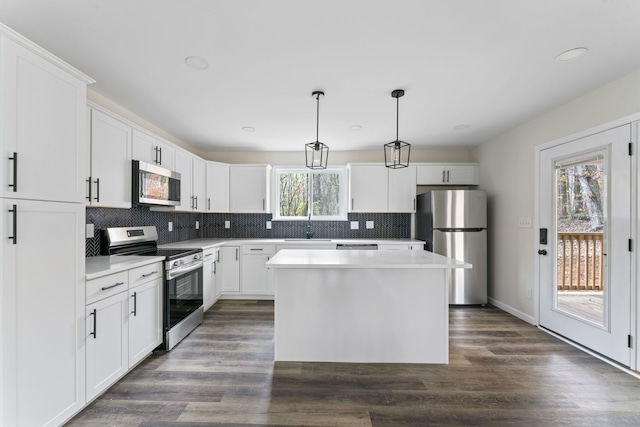 kitchen featuring pendant lighting, dark wood-type flooring, plenty of natural light, and stainless steel appliances