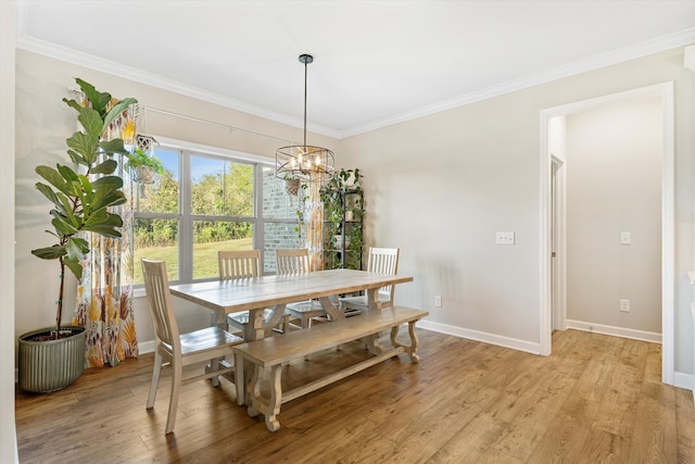 dining area featuring an inviting chandelier, ornamental molding, and light wood-type flooring