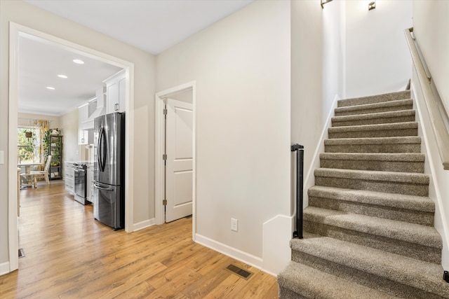 staircase featuring crown molding and wood-type flooring