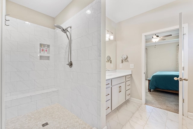 bathroom with vanity, ceiling fan, and a tile shower