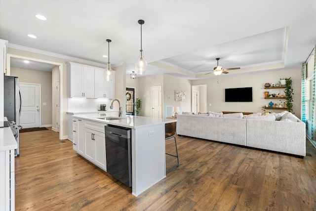 kitchen featuring sink, stainless steel appliances, an island with sink, pendant lighting, and white cabinets