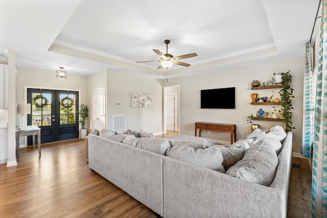 living room with french doors, a raised ceiling, ceiling fan, and dark wood-type flooring