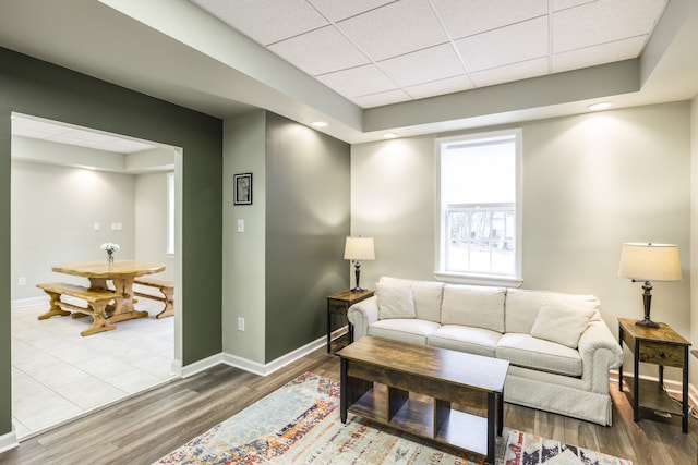 living room featuring hardwood / wood-style floors and a drop ceiling