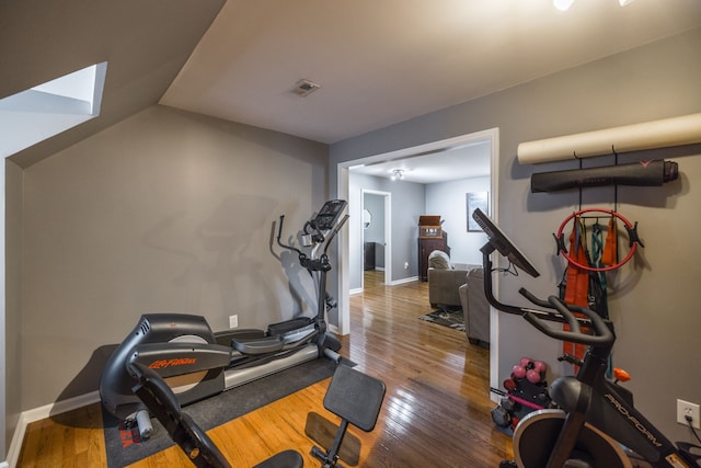 exercise area with wood-type flooring and lofted ceiling