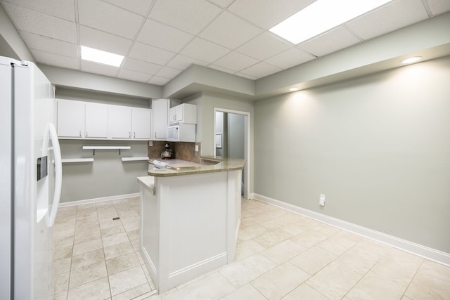 kitchen featuring white cabinetry, light tile patterned flooring, white appliances, and kitchen peninsula