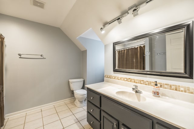 bathroom with vanity, vaulted ceiling, tile patterned flooring, toilet, and curtained shower