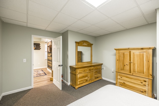 bedroom featuring dark colored carpet and a drop ceiling