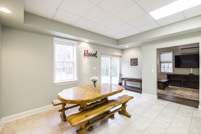 tiled dining room with a drop ceiling