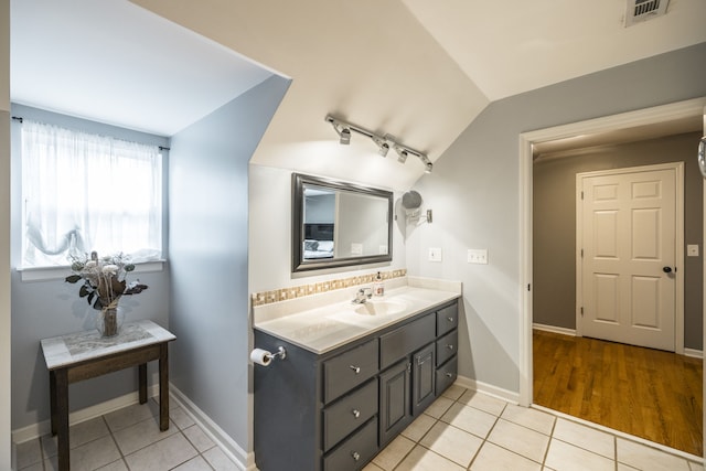 bathroom featuring vanity, vaulted ceiling, and hardwood / wood-style flooring