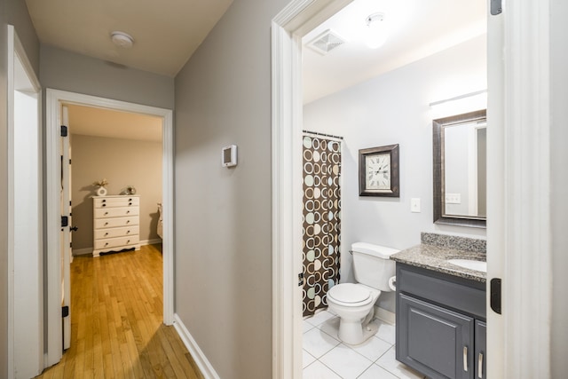 bathroom with walk in shower, vanity, wood-type flooring, and toilet