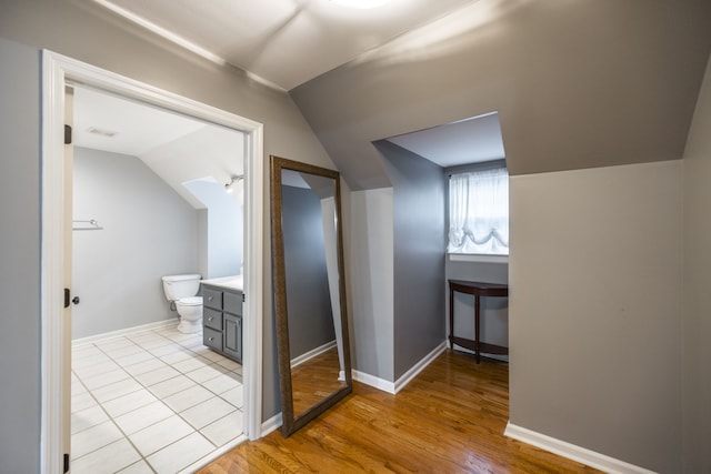 hallway featuring light hardwood / wood-style flooring and vaulted ceiling