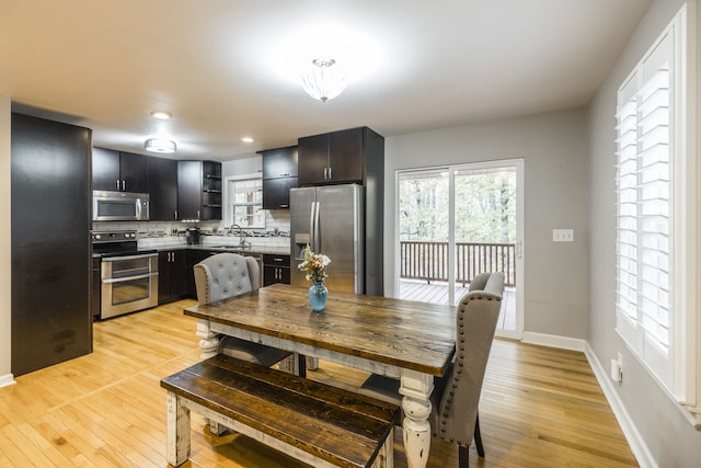 dining room with sink and light wood-type flooring