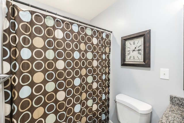 bathroom featuring a shower with curtain and toilet