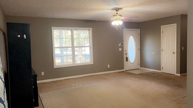 foyer with carpet flooring, ceiling fan, and a textured ceiling