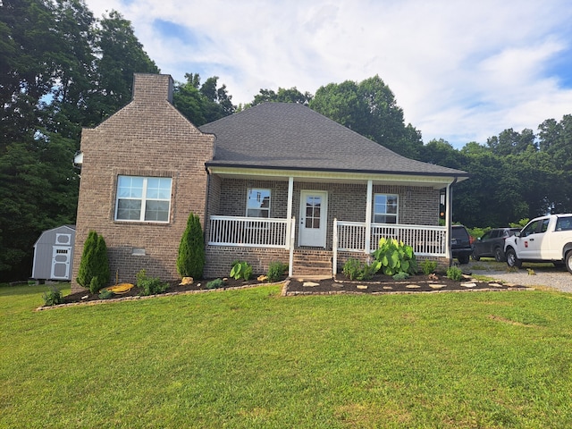 view of front of property featuring a porch, a shed, and a front lawn