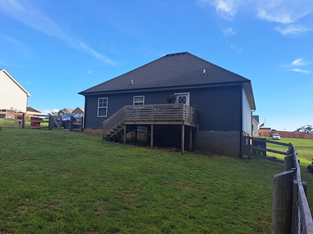 rear view of house with a yard and a deck