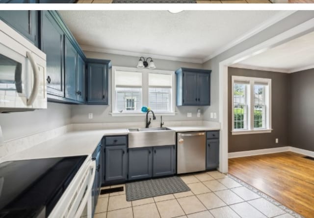 kitchen featuring blue cabinetry, stainless steel dishwasher, crown molding, and light tile patterned flooring