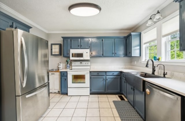 kitchen with blue cabinets, ornamental molding, and appliances with stainless steel finishes