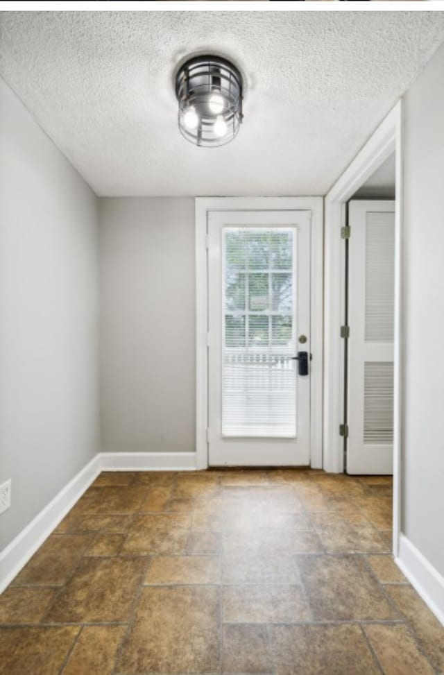 doorway with a textured ceiling