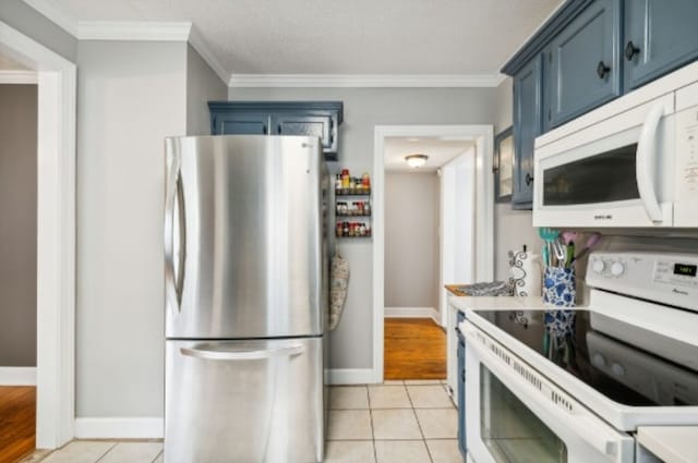 kitchen featuring blue cabinetry, light tile patterned floors, white appliances, and ornamental molding