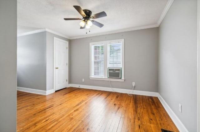 spare room with ceiling fan, cooling unit, ornamental molding, and hardwood / wood-style flooring