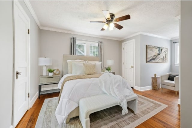 bedroom featuring a textured ceiling, hardwood / wood-style flooring, ceiling fan, and crown molding