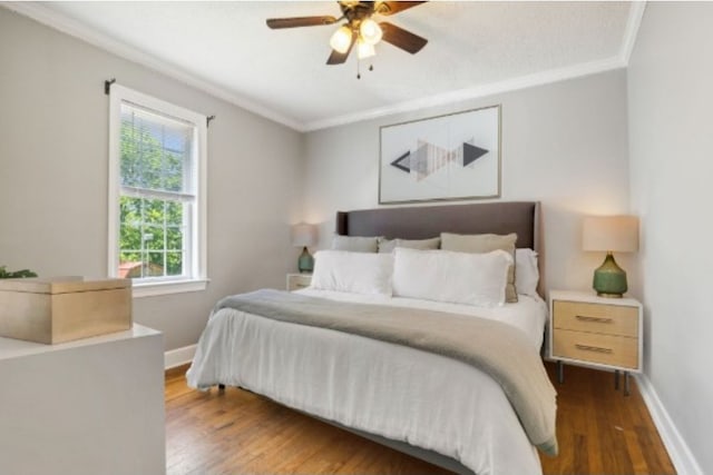 bedroom with ceiling fan, dark hardwood / wood-style flooring, and ornamental molding