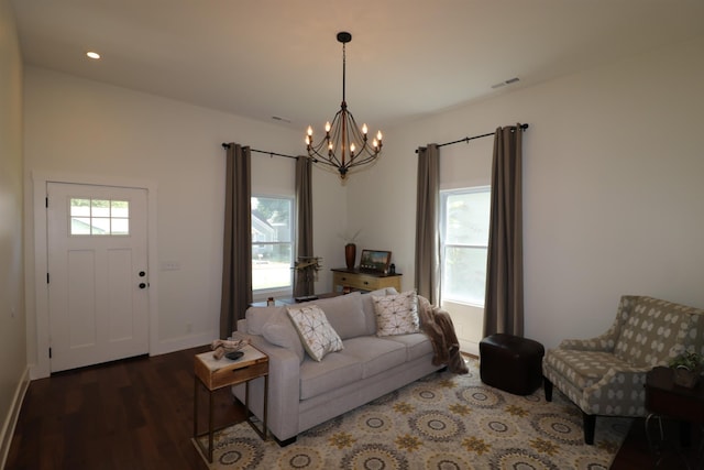 living room with dark hardwood / wood-style flooring and a notable chandelier