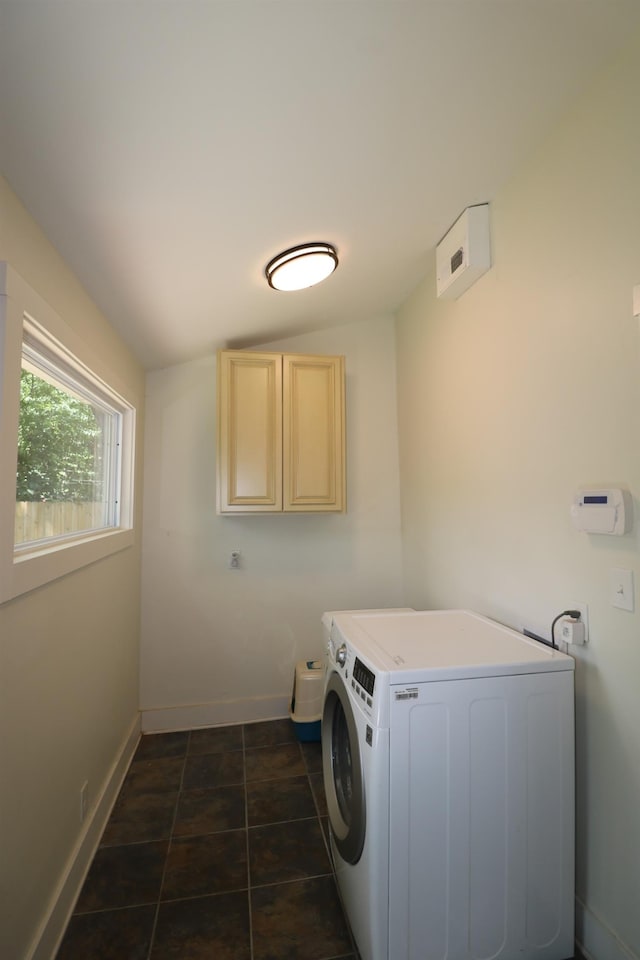 washroom with cabinets, dark tile patterned flooring, and washer / dryer