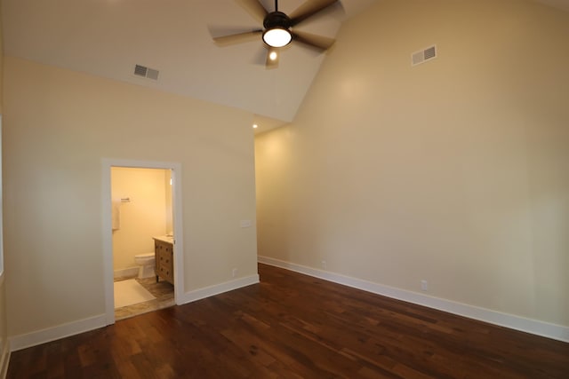 interior space featuring dark hardwood / wood-style floors, ceiling fan, vaulted ceiling, and ensuite bath