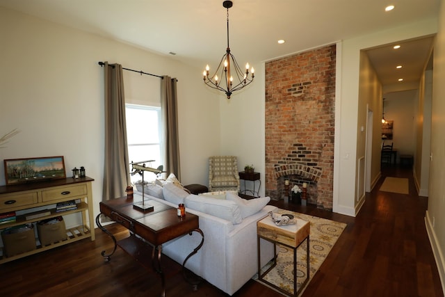 living room featuring a fireplace, dark hardwood / wood-style flooring, and a notable chandelier