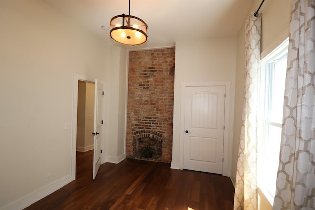 hall featuring dark hardwood / wood-style floors and brick wall